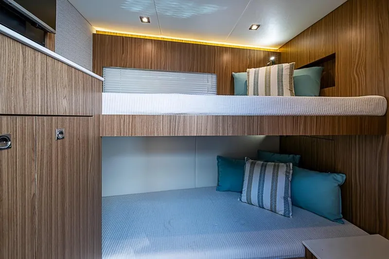 Slide: The Image of 2025 Cruisers Yachts 50 Cantius interior with modern wood finish and cozy bunk beds. - 33