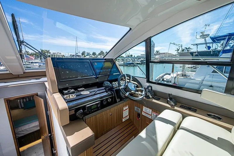 Slide: The Image of 2025 Cruisers Yachts 50 Cantius helm with modern controls and marina view. - 4