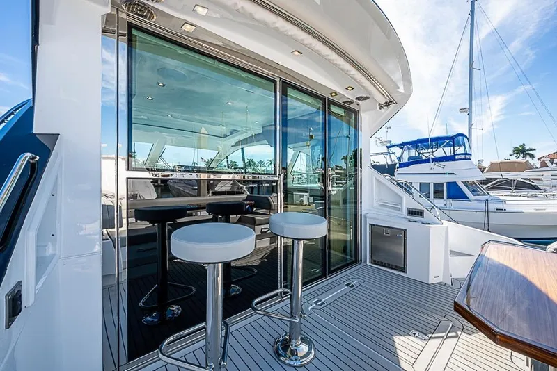Slide: The Image of 2025 Cruisers Yachts 50 Cantius luxury deck with bar stools and marina view. - 47