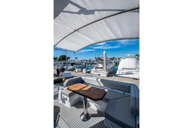 Slide: The Image of 2025 Cruisers Yachts 50 Cantius, docked with covered seating area and marina view. - 49