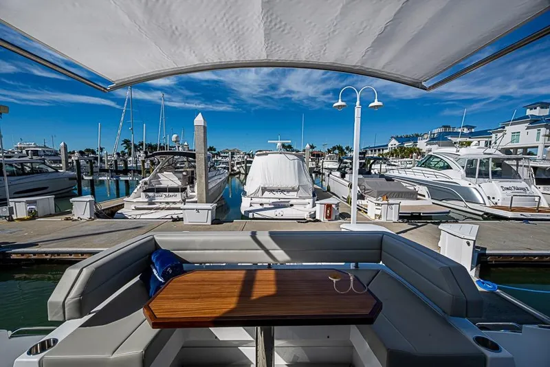 Slide: The Image of Luxurious 2025 Cruisers Yachts 50 Cantius docked at a marina under clear blue skies. - 50