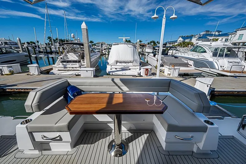 Slide: The Image of 2025 Cruisers Yachts 50 Cantius, luxurious seating area in a marina setting. - 51