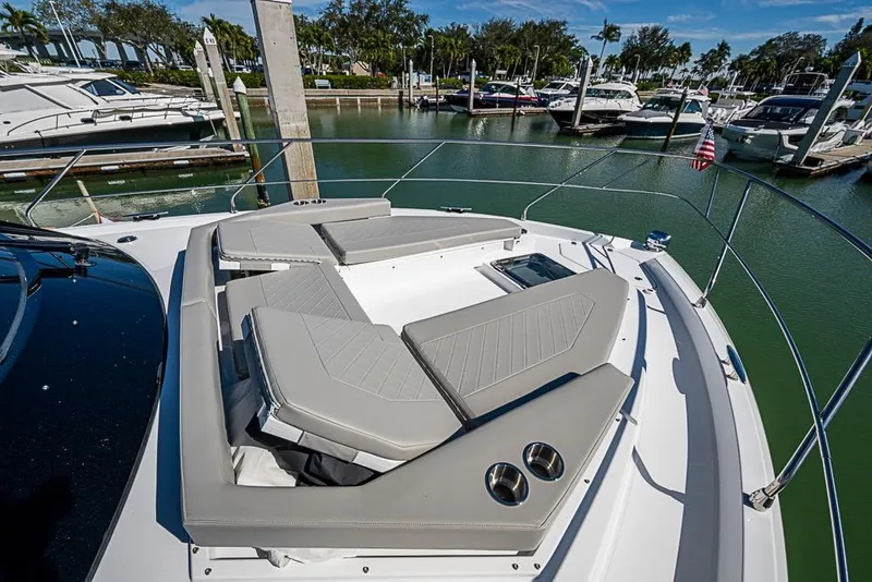 Slide: The Image of 2025 Cruisers Yachts 50 Cantius luxury deck with cushioned seating in marina setting. - 54
