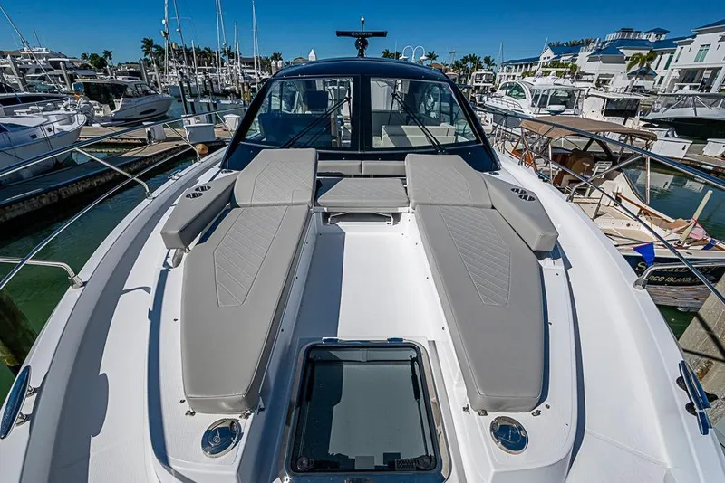Slide: The Image of 2025 Cruisers Yachts 50 Cantius luxury deck with sun loungers in marina setting. - 56