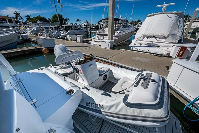 Slide: The Image of 2025 Cruisers Yachts 50 Cantius docked at marina with inflatable tender. - 58