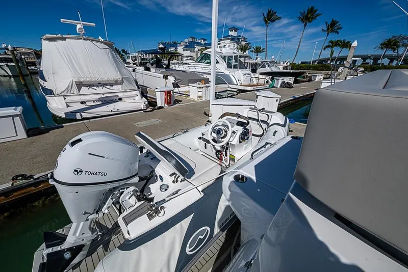 Slide: The Image of 2025 Cruisers Yachts 50 Cantius docked, featuring Tohatsu outboard motor, marina setting. - 60