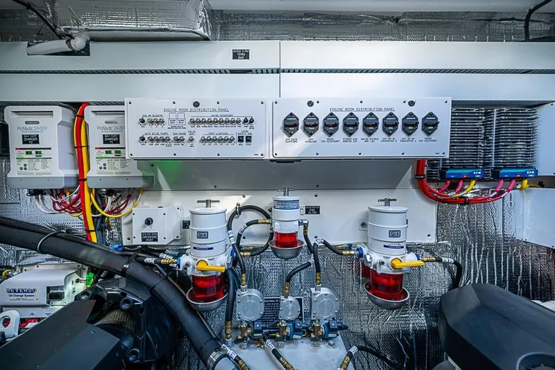 Slide: The Image of Engine room of 2025 Cruisers Yachts 50 Cantius, showcasing electrical panels and fuel filters. - 70