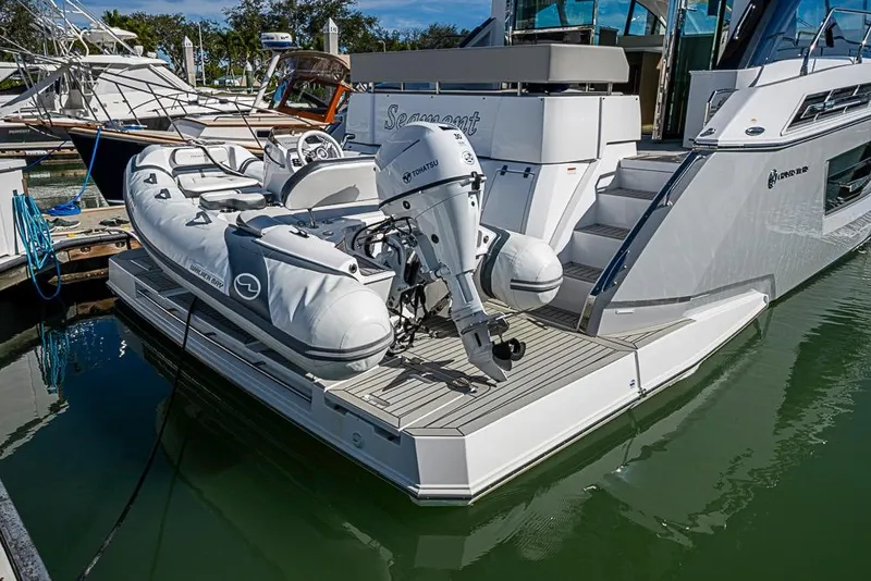 Slide: The Image of 2025 Cruisers Yachts 50 Cantius with inflatable boat and Tohatsu motor at marina. - 76