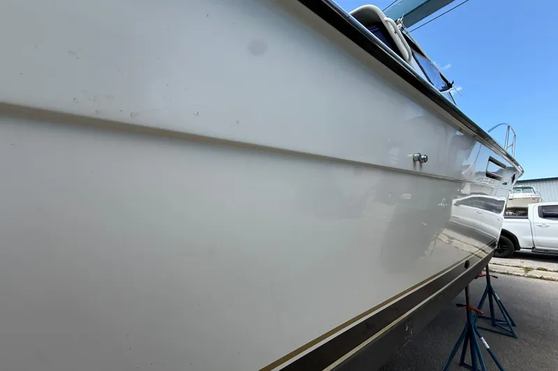 Slide: The Image of 1995 Tiara Yachts 3100 Open boat side view, elevated on stands, with a truck nearby. - 8