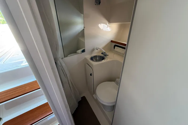 Slide: The Image of Compact bathroom in a 1995 Tiara Yachts 3100 Open, featuring sink and toilet. - 25