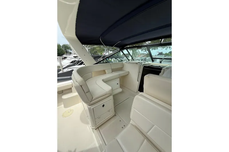 Slide: The Image of 1995 Tiara Yachts 3100 Open interior with cream seating and blue canopy. - 4