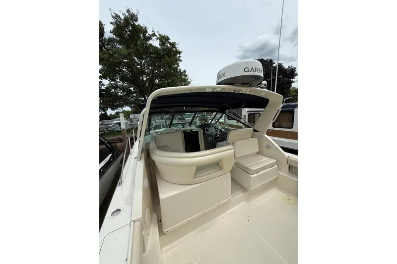 Slide: The Image of 1995 Tiara Yachts 3100 Open boat with Garmin radar, docked near trees. - 1