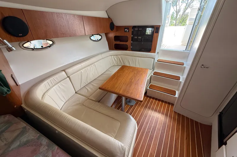 Slide: The Image of Interior of 1995 Tiara Yachts 3100 Open with leather seating and wooden table. - 21
