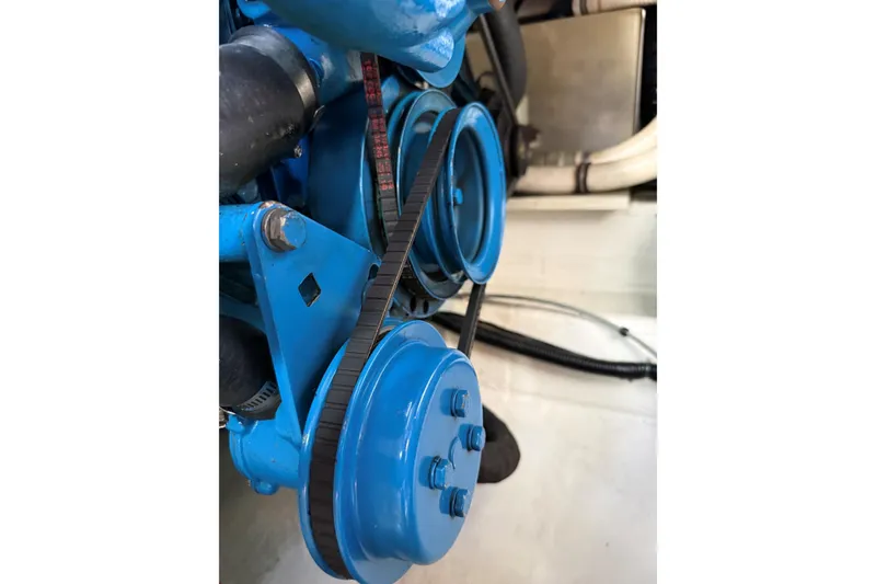 Slide: The Image of Engine components of a 1995 Tiara Yachts 3100 Open, featuring blue pulleys and belts. - 31