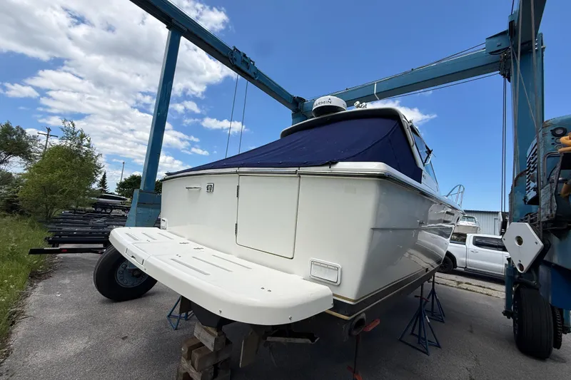 Slide: The Image of 1995 Tiara Yachts 3100 Open on dry dock, featuring a sleek white hull and blue cover. - 12