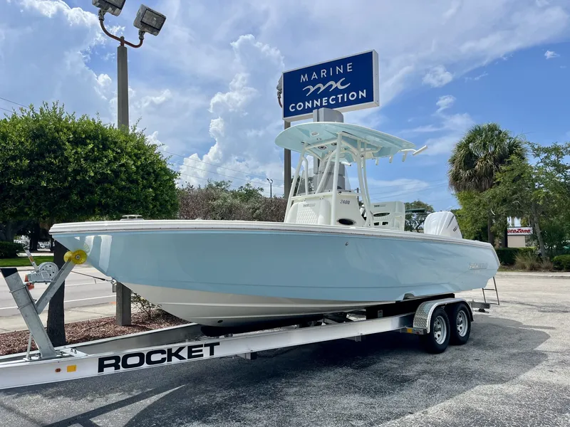 Slide: The Image of A 2027 Pathfinder 2400 Hybrid boat on a trailer, parked in a lot under a blue sky. - 2