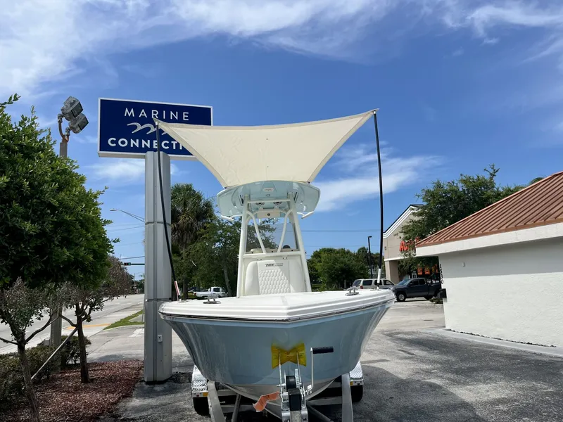 Slide: The Image of A white boat on a trailer in front of a building, with a sunshade above. - 32