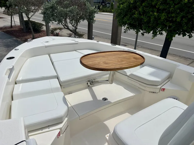 Slide: The Image of The boat features white cushions and a round wooden table in the foreground. - 17
