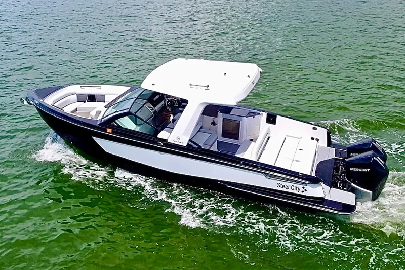 The Image of 2022 Aviara AV32 OB boat cruising on green water, featuring sleek design and dual Mercury engines. - 1