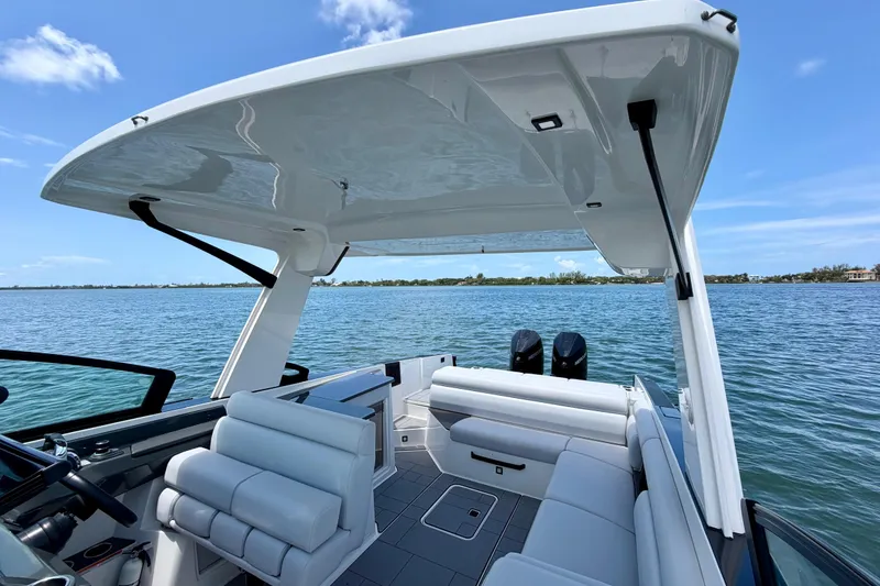 Slide: The Image of 2022 Aviara AV32 OB boat interior with seating and canopy on a sunny day. - 26