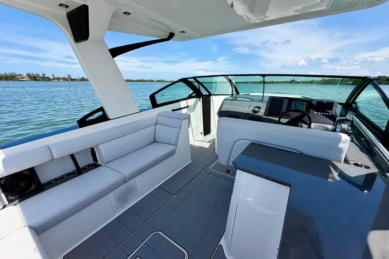 Slide: The Image of 2022 Aviara AV32 OB boat interior with sleek seating and modern dashboard on a sunny day. - 27