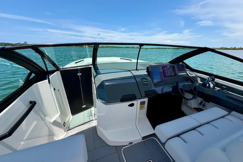 Slide: The Image of 2022 Aviara AV32 OB boat cockpit with modern controls and seating on a sunny day. - 30