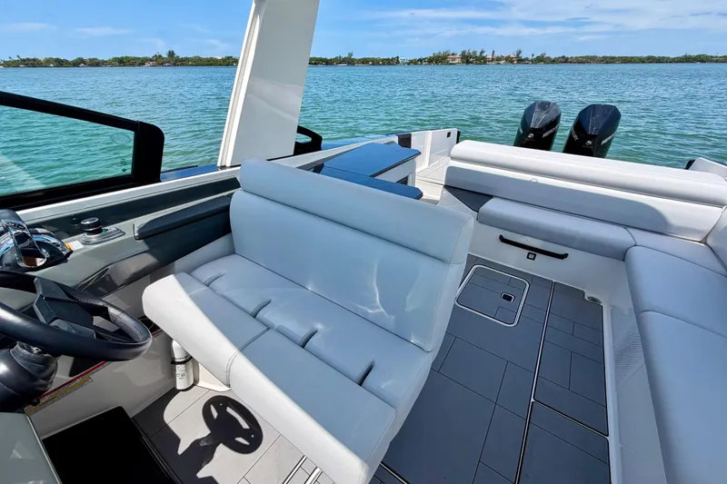 Slide: The Image of 2022 Aviara AV32 OB boat interior with luxurious seating and dual outboard motors on a serene lake. - 33