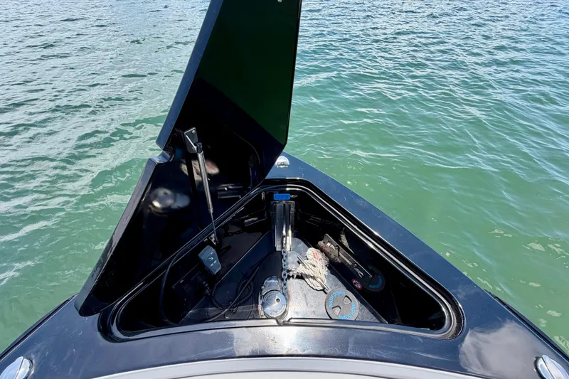 Slide: The Image of Open storage compartment on 2022 Aviara AV32 OB boat, with water in the background. - 36