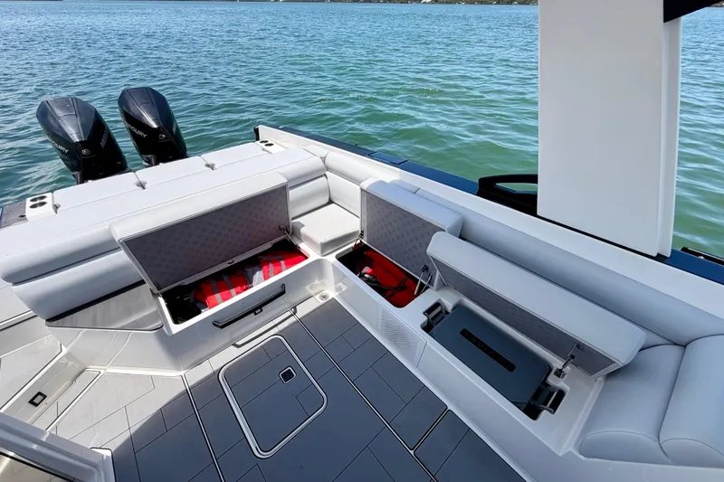 Slide: The Image of 2022 Aviara AV32 OB boat interior with open storage compartments and twin outboard engines. - 43