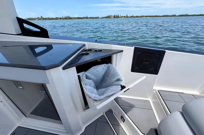 Slide: The Image of 2022 Aviara AV32 OB boat interior with open trash compartment and ocean view. - 46