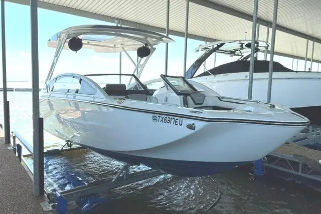 The Image of 2021 Yamaha Boats 275SD on lift at marina, sleek design, under covered dock. - 0