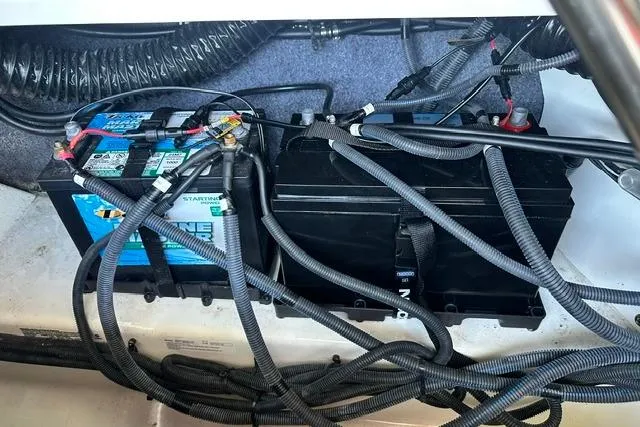 Slide: The Image of 2021 Yamaha Boats 275SD battery compartment with wiring and connections. - 11