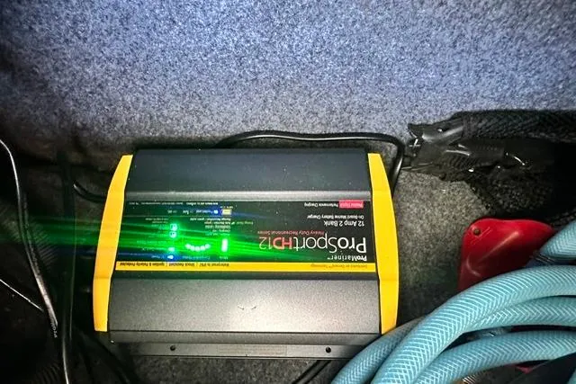 Slide: The Image of Battery charger in a 2021 Yamaha Boats 275SD, with visible cables and indicators. - 17