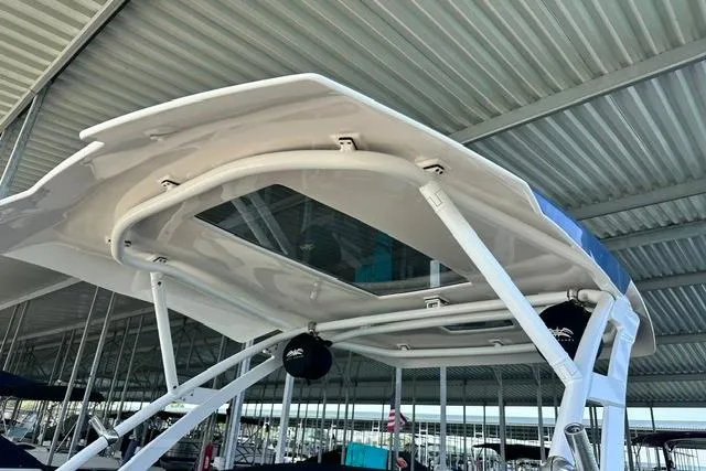 Slide: The Image of 2021 Yamaha Boats 275SD with sleek canopy design in a covered marina. - 18