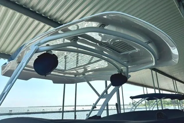 Slide: The Image of 2021 Yamaha Boats 275SD with sleek canopy design docked under shelter. - 19