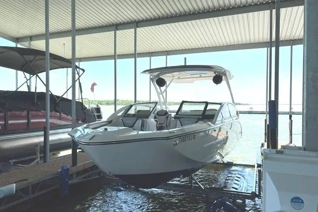 The Image of 2021 Yamaha Boats 275SD docked under a covered marina, showcasing sleek design and modern features. - 3