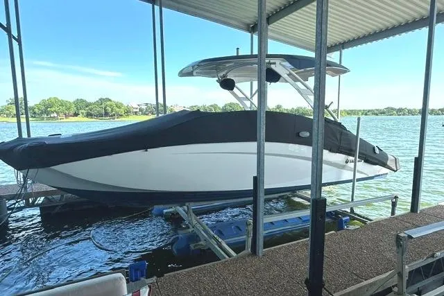Slide: The Image of 2021 Yamaha Boats 275SD docked under a covered marina on a sunny day. - 6
