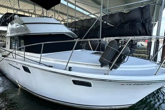 The Image of 1989 Carver 32 Aft Cabin Motor Yacht docked under a covered marina. - 0