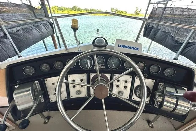 Slide: The Image of 1989 Carver 32 Aft Cabin Motor Yacht helm with steering wheel and navigation instruments. - 11