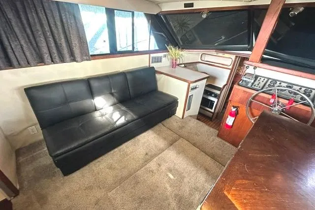Slide: The Image of Interior of 1989 Carver 32 Aft Cabin Motor Yacht with black sofa and helm. - 14
