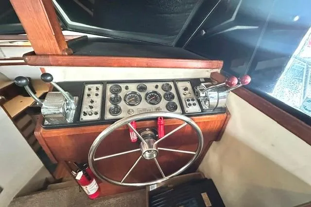 Slide: The Image of 1989 Carver 32 Aft Cabin Motor Yacht helm with steering wheel and control panel. - 15