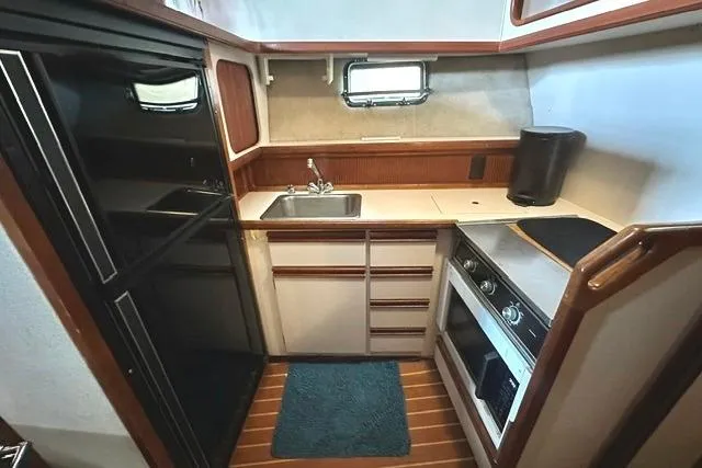 Slide: The Image of Compact kitchen in 1989 Carver 32 Aft Cabin Motor Yacht with sink, stove, and fridge. - 16