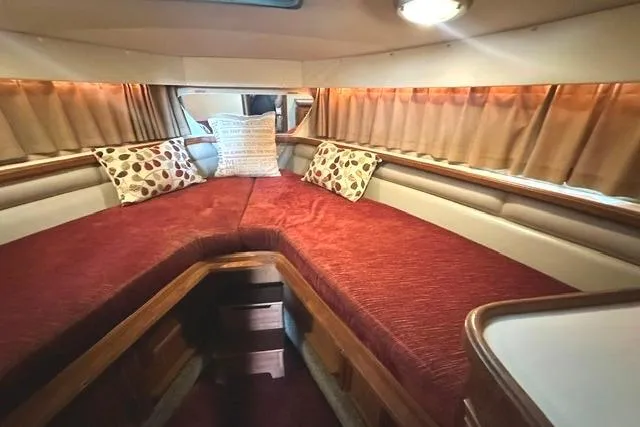 Slide: The Image of 1989 Carver 32 Aft Cabin Motor Yacht interior with red bedding and decorative pillows. - 18