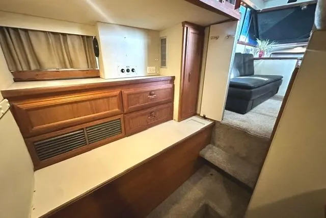 Slide: The Image of Interior of 1989 Carver 32 Aft Cabin Motor Yacht with wood cabinetry and carpeted steps. - 23