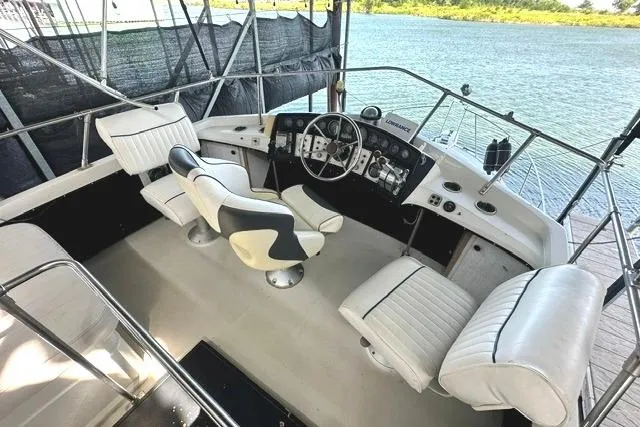 Slide: The Image of 1989 Carver 32 Aft Cabin Motor Yacht cockpit with white seating and steering controls. - 7