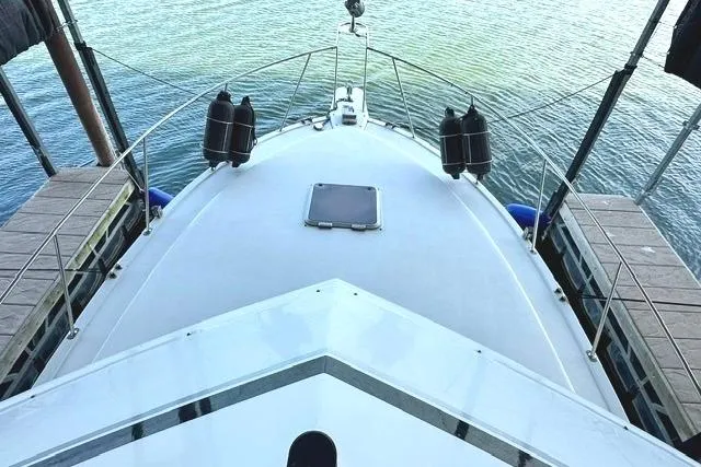 Slide: The Image of 1989 Carver 32 Aft Cabin Motor Yacht docked, view from bow, calm water. - 9