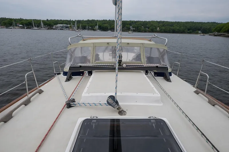Slide: The Image of 1992 Morris Ocean Series 44 sailboat deck with ropes and canopy, moored on a calm lake. - 12