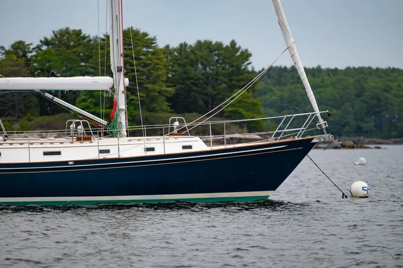 Slide: The Image of Sailboat Morris Ocean Series 44, 1992 model, anchored on calm water with forest backdrop. - 64