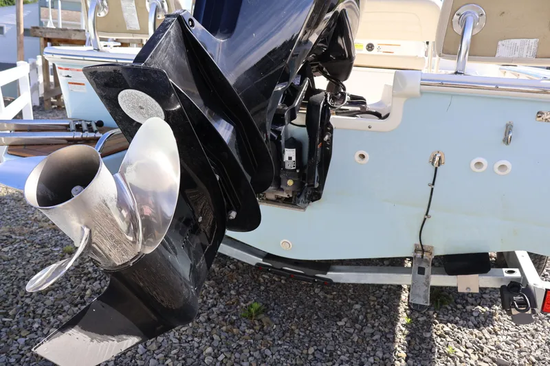 Slide: The Image of 2023 Boston Whaler 170 Montauk boat engine and propeller detail on gravel surface. - 12