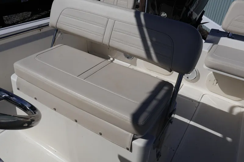 Slide: The Image of 2023 Boston Whaler 170 Montauk boat seat with beige upholstery and steering wheel. - 22